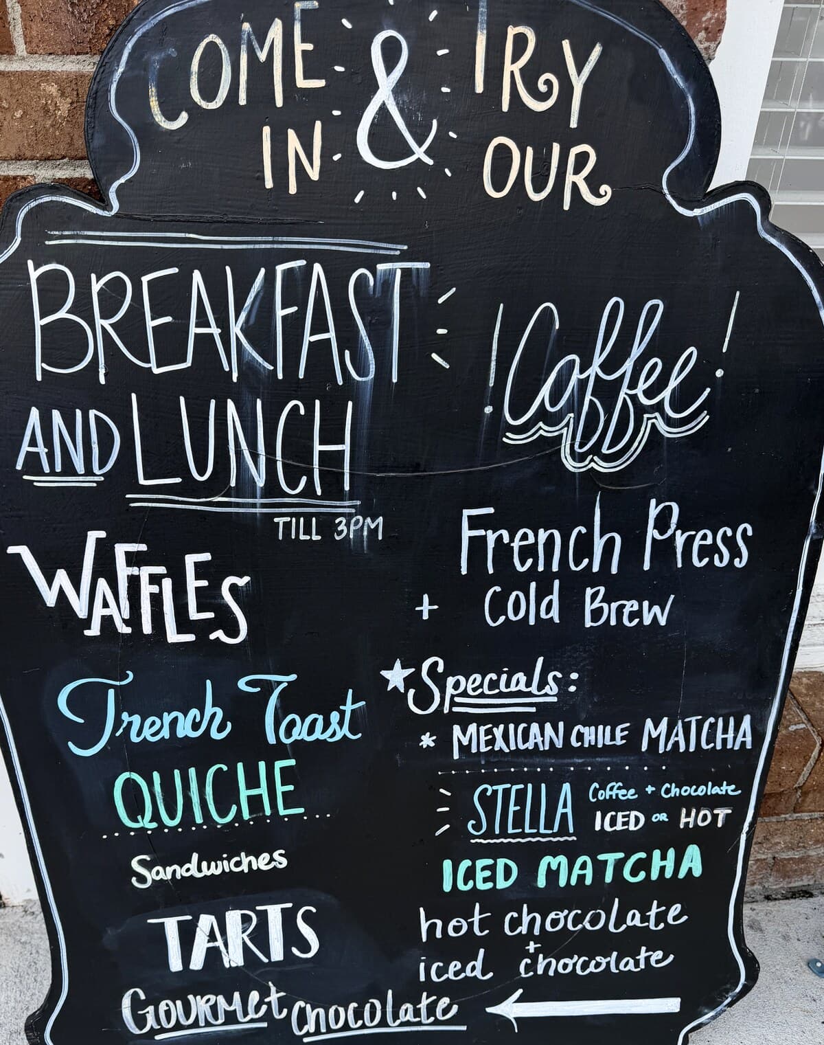 The café chalkboard at West Ashley: breakfast and lunch until 3pm, coffee, French press, cold brew, matcha and hot chocolate